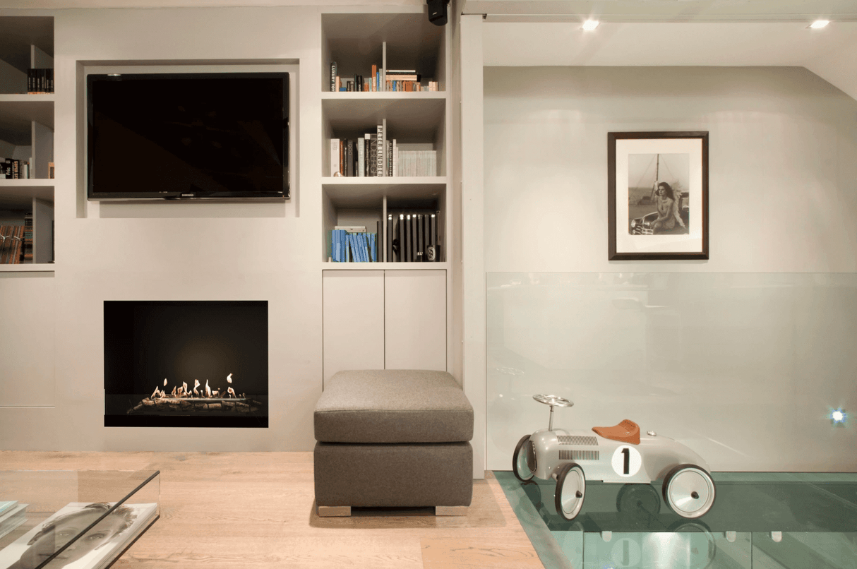 EcoSmart Heritage 56SS Ethanol Fireplace Insert installed in a modern living room with built-in shelves and a mounted TV. Ideal for stylish indoor heating.