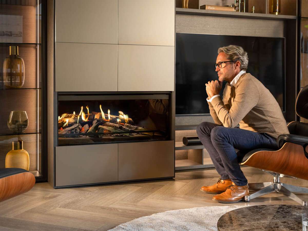 NetZero Fire E-One 130F 3D Electric Fireplace - Front - AA-11-05387 installed in a modern living room with a man seated nearby admiring the realistic flame effect.