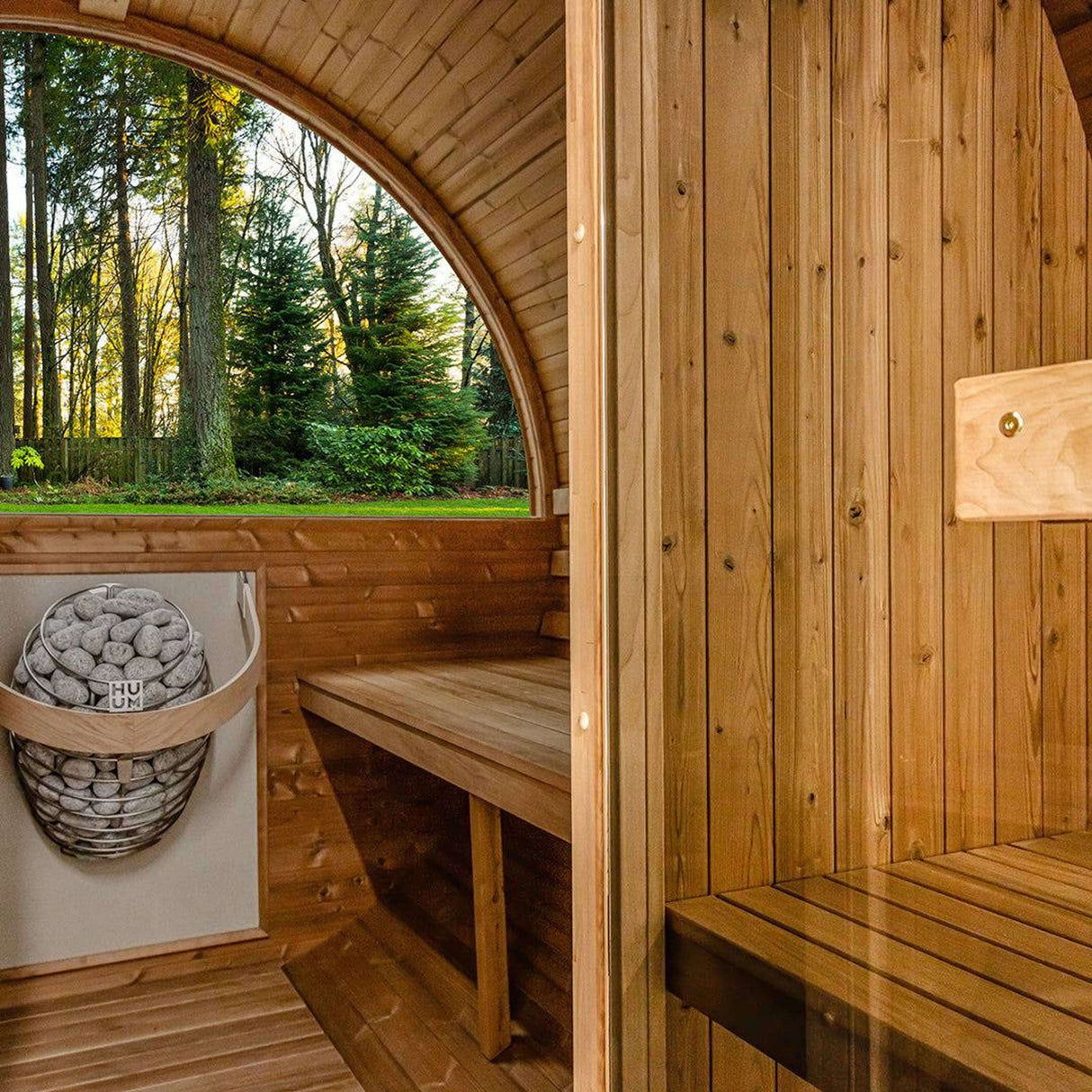 Detailed interior view of Thermory Barrel Sauna Model #60 DIY Kit showing heater, benches, and wood paneling. Premium DIY outdoor sauna kit.