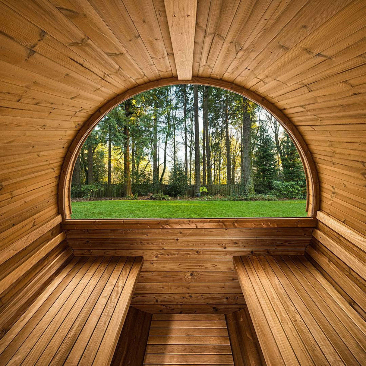 Interior of Thermory Barrel Sauna Model #60 DIY Kit with panoramic window and wood benches. Ideal for 4-person outdoor sauna sessions.