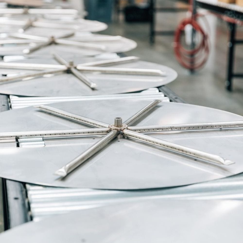 Close-up of Firegear DIY Fire Pit Kit - Round burner components in production, showcasing stainless steel construction and quality.