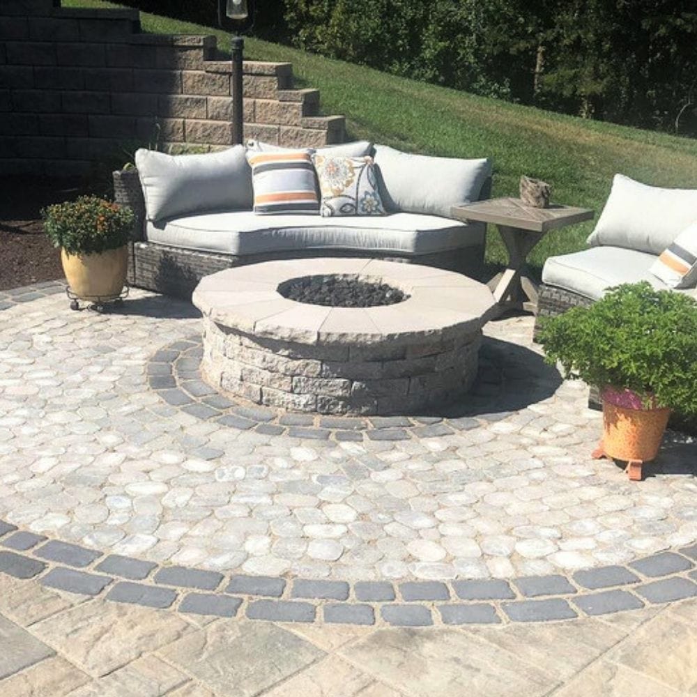 Circular stone patio with Firegear DIY Fire Pit Kit - Round, surrounded by cushioned seating for a stylish outdoor retreat.
