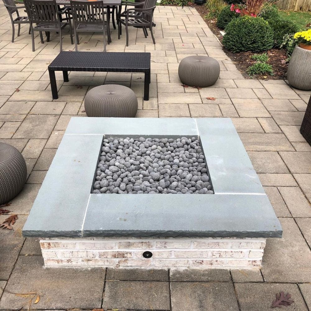 Brick fire pit with Firegear DIY Fire Pit Kit - Square filled with lava stones, ideal for backyard patios and outdoor lounging.