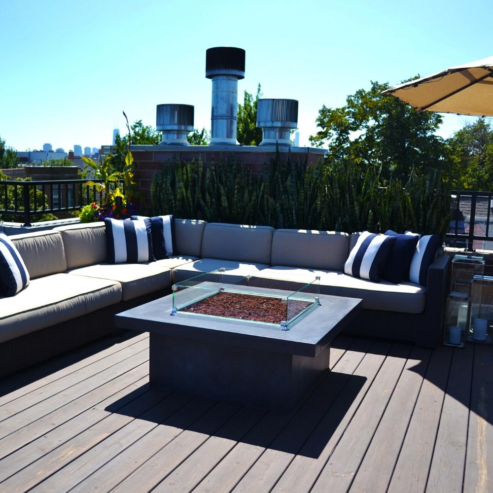 Rooftop deck with sectional sofa and Firegear DIY Fire Pit Kit - Square in a modern square base with lava rock and glass guard.