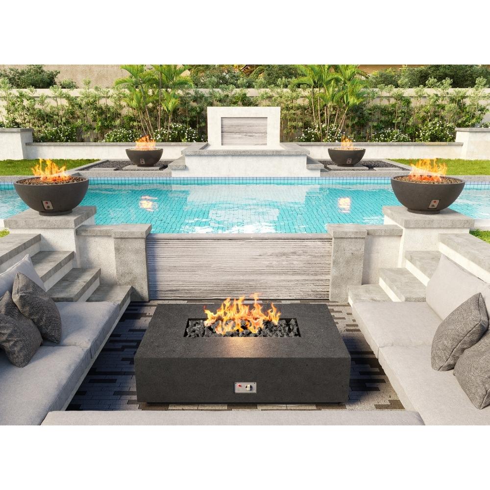 Modern outdoor patio with Firegear Sanctuary 30-Inch Round Concrete Gas Fire Bowls flanking a pool, creating a stylish ambiance.