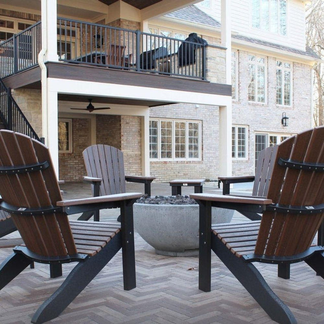 Backyard patio with Adirondack chairs surrounding Firegear Sanctuary 30-Inch Round Concrete Gas Fire Bowl for outdoor gatherings.