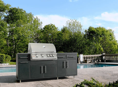 Challenger Coastal 7 foot outdoor kitchen island with a Blaze 32 inch gas grill and refrigerator on dark gray cabinets beside a pool