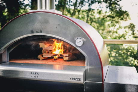Alfa 4 Pizze wood-fired pizza oven with logs burning in the oven chamber