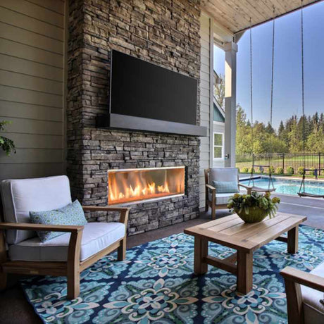 Majestic Lanai 60 outdoor linear gas fireplace in a poolside lounge with amber crushed glass