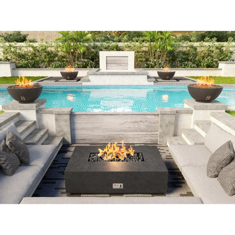 Modern outdoor patio with Firegear Sanctuary 30-Inch Round Concrete Gas Fire Bowls flanking a pool, creating a stylish ambiance.